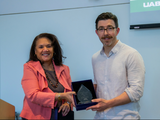 Dean Kecia M. Thomas present the Montaigne Prize to Dr. Jordan Kiper.