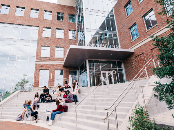Anthropology Class being held on the large stairway outside of University Hall. From side, Dr. Lisa Gezon, PhD (Professor/Chair, Anthropology) is teaching a group of students on steps, April 2023. 