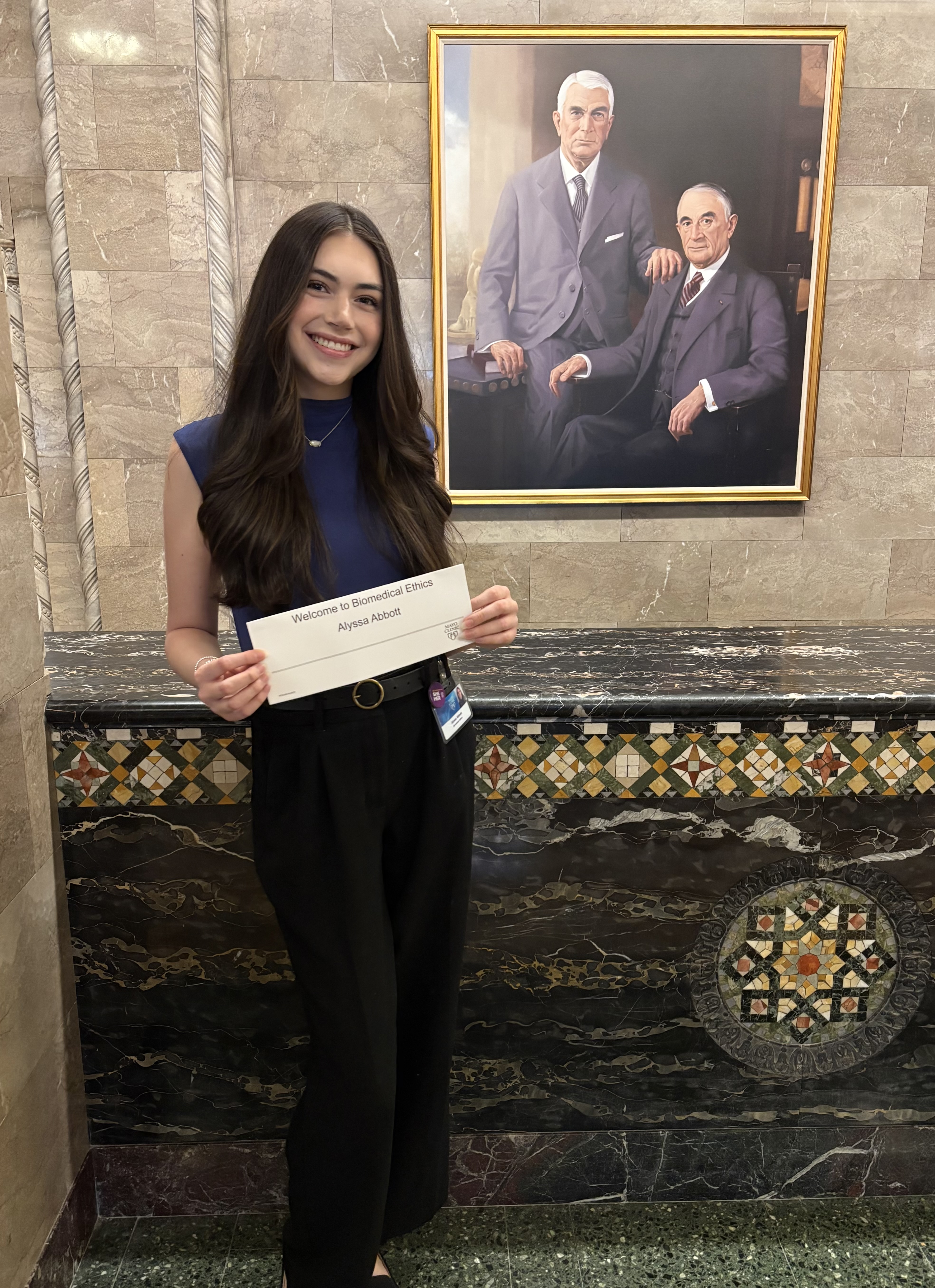 Alyssa Abbot holding up her name placard at the Mayo Clinic 