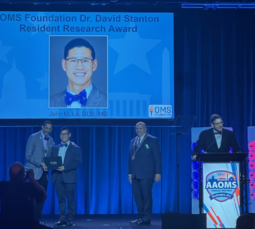 Dr. Le receiving the OMS Foundation David Stanton Resident Research Award at AAOMS 2025 Annual Meeting.