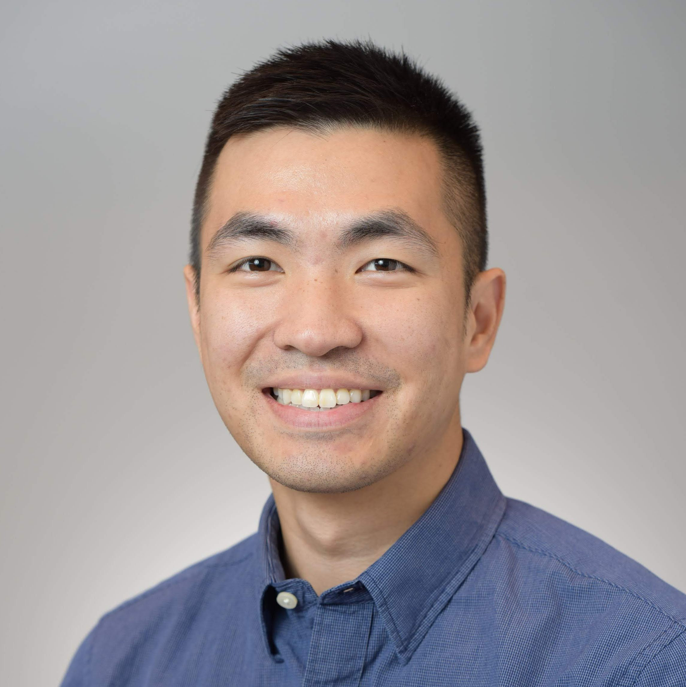 Dr. Liu, a man with blue button up smiling for photo