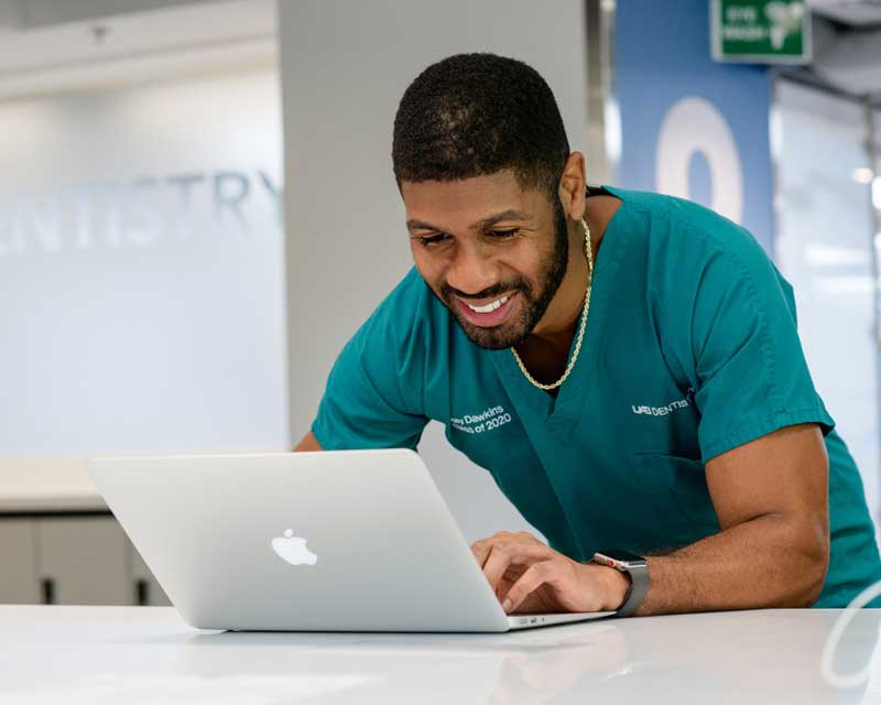 Student with laptop working in a clinic.