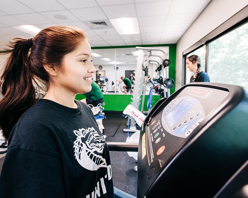 Young woman running on a treadmill in one of UAB's kinesiology labs. 