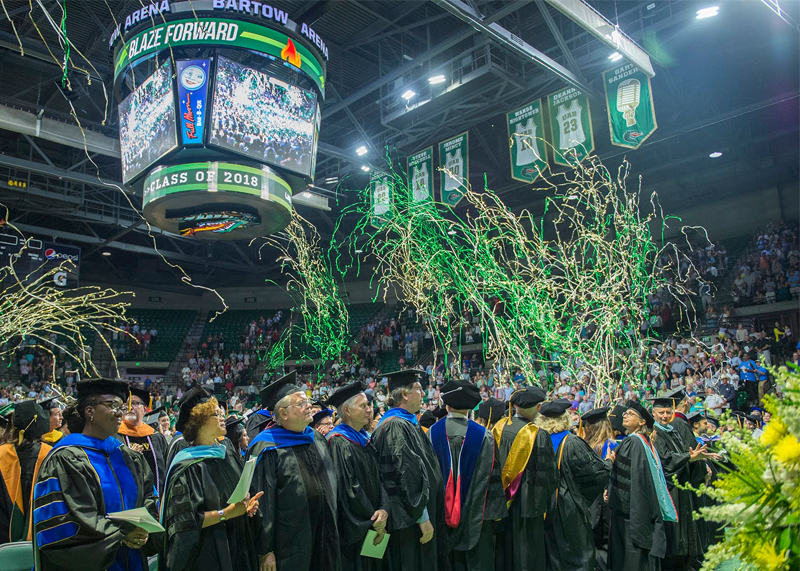 Students wearing caps and gowns celebrating. 