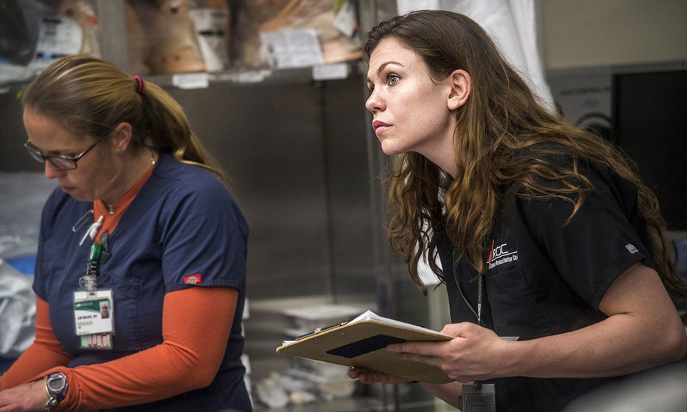 Farley takes a close look at the trauma patient's vital signs. If a blood transfusion is needed, the patient may be a candidate for one of the 19 research protocols run by the Emergency Department research assistants. (UAB News)