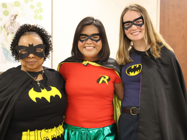 Three people dressed in Batman-themed Halloween costumes