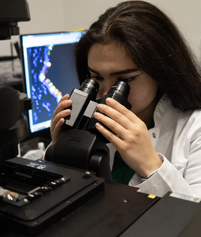 Javahir Hajibabazade using a microscope.