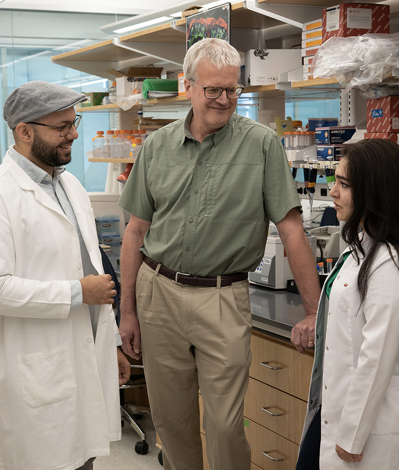 Mohammed Mohsen Hassan Abdalla, Dr. Engelhardt, and Javahir Hajibabazade speaking by lab bench.