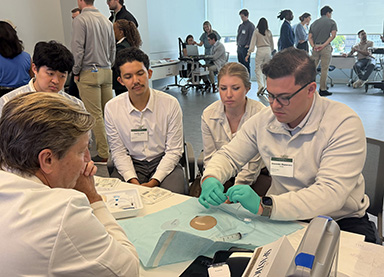 Dr. Brunner teaches medical students a procedure during a conference workshop