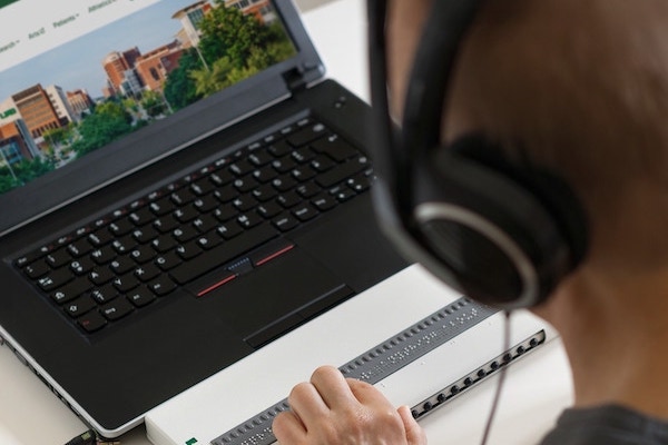Person using a laptop with assistive technology