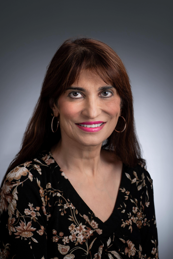 Ashita Tolwani, M.D., stands in front of a gray background.