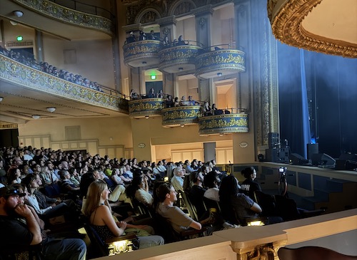 A full theater full of audience members watching the Best Medicine Show.