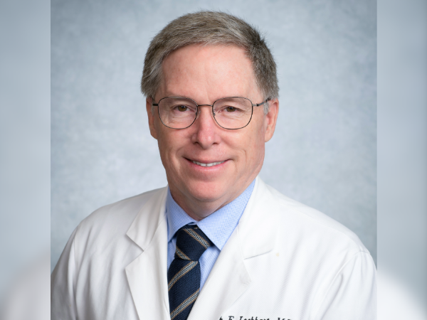 Dr. Lockhart headshot in a white coat and tie