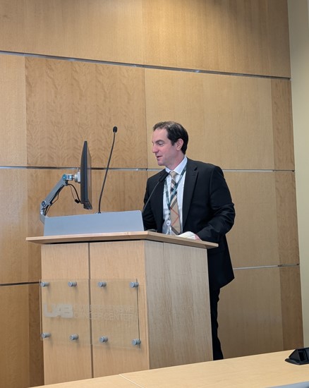 Dr. Mossa-Basha speaking at a podium