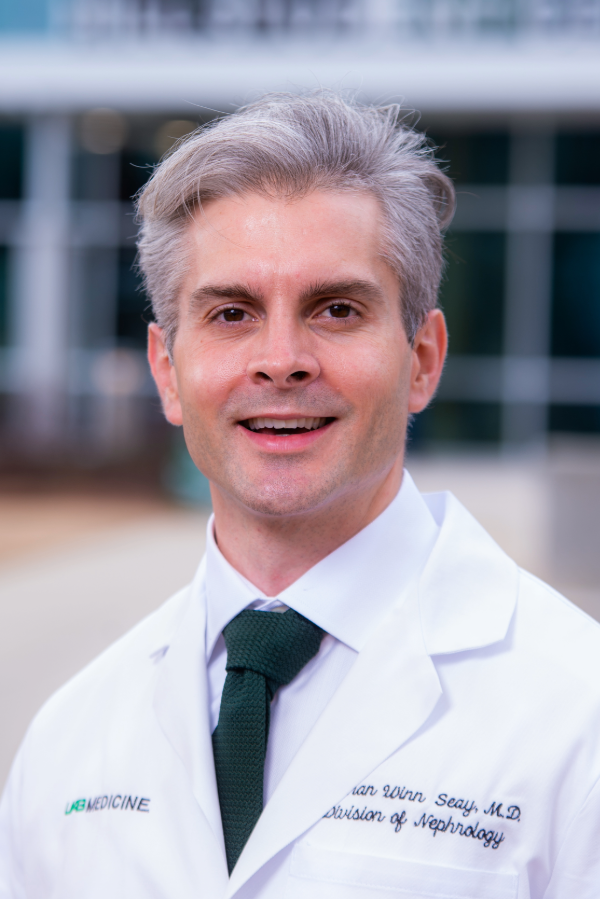 Winn Seay, M.D., stands in front of a building.