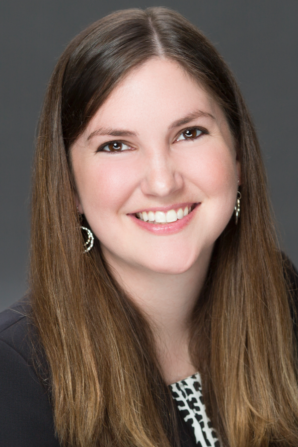 Rachel Skains, M.D., stands in front of a gray background.