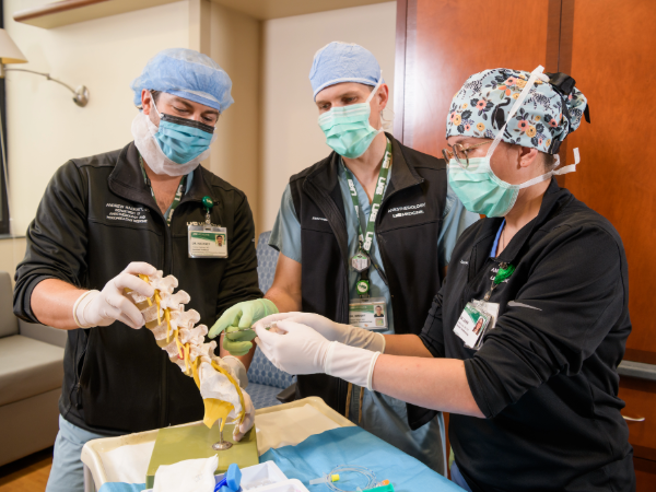 UAB Anesthesiology residents practice a spinal procedure using a spine model during clinical training.