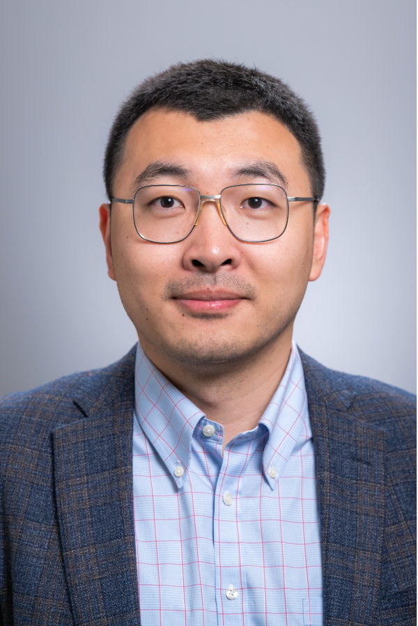 Fengbin “Jerry” Wang, Ph.D., stands in front of a gray background.