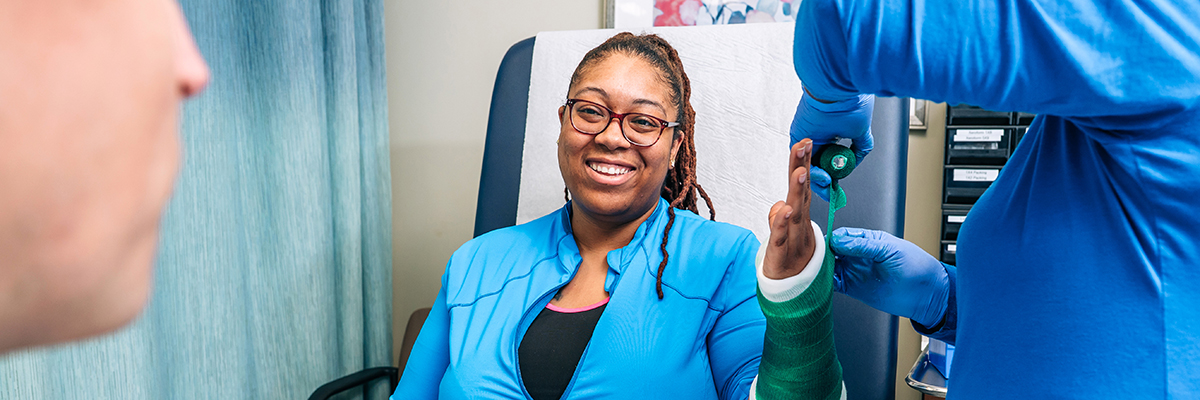 Doctor taping up cast on patient