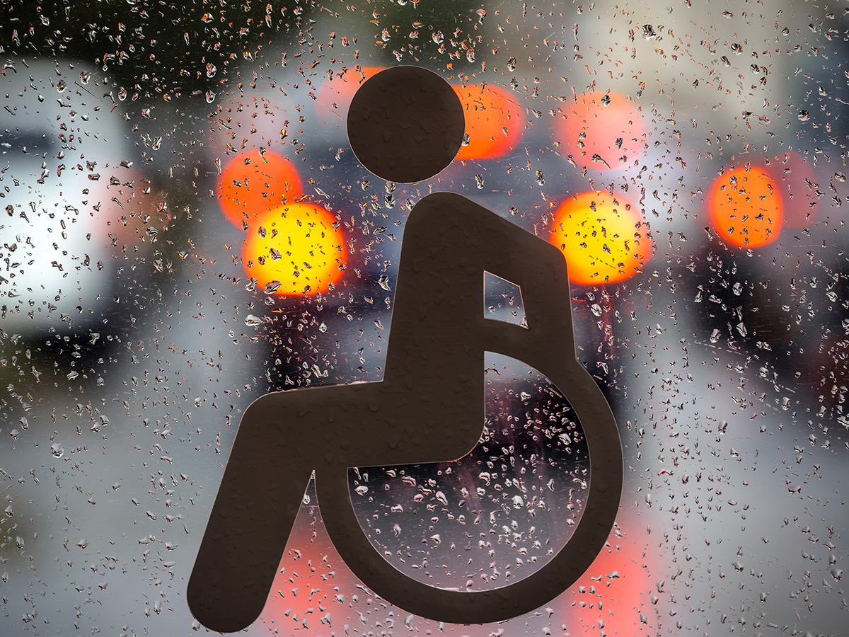 Accessibility logo on rain dripped window.