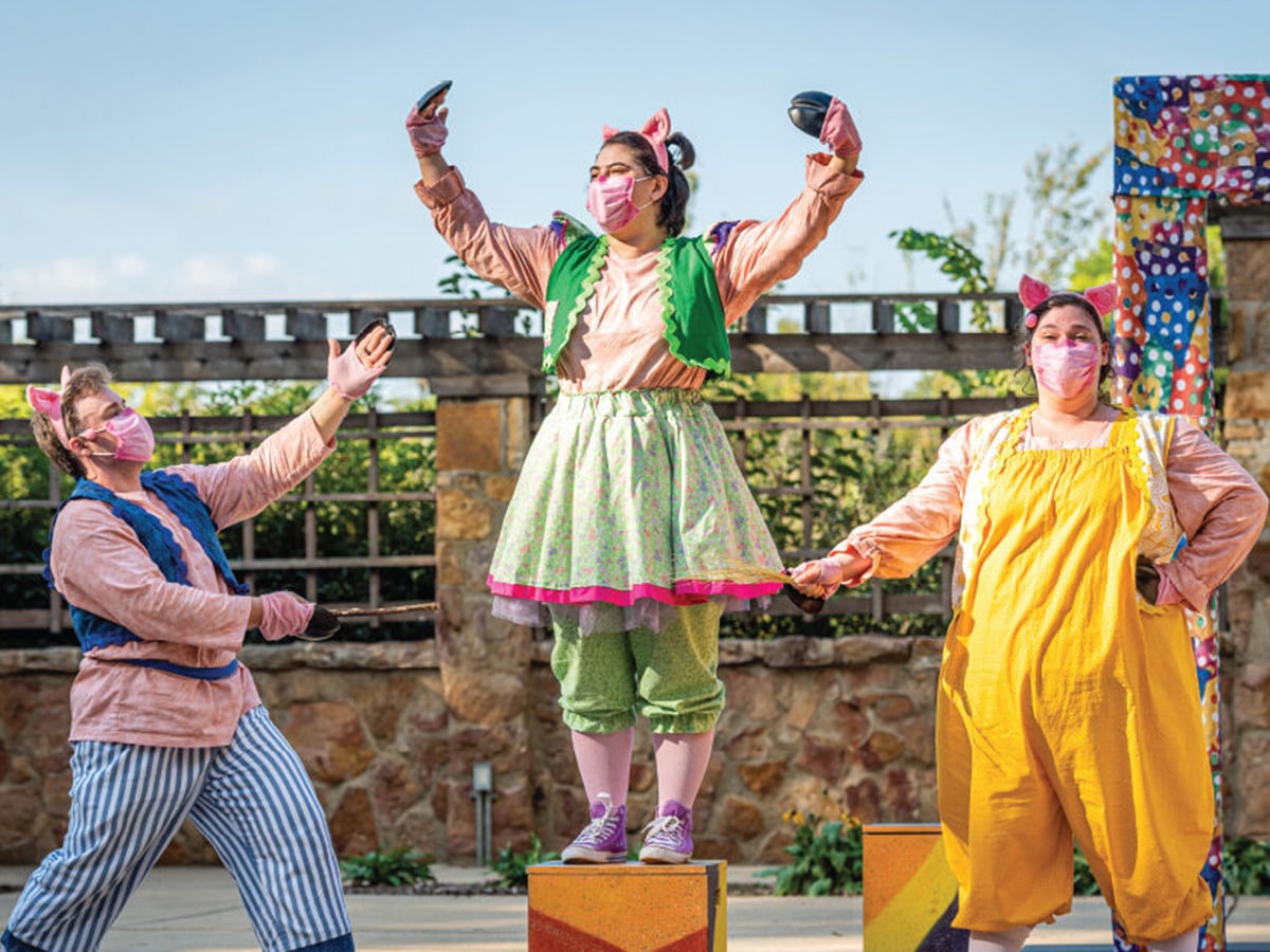 Costumed man and two women performing