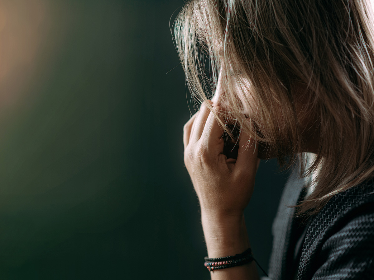 Blonde haired woman sitting in dark