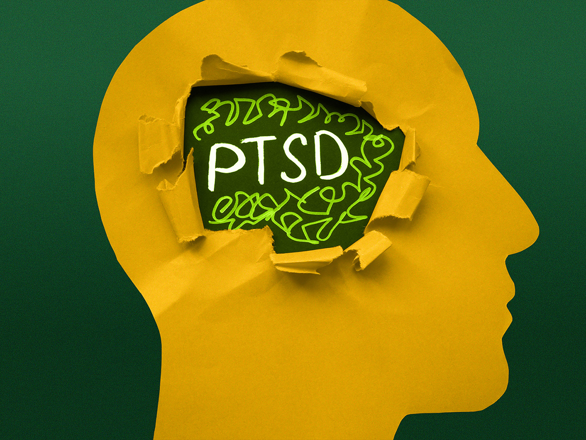 Silhouette of a face in yellow with hand drawn brain with the letters PTSD.