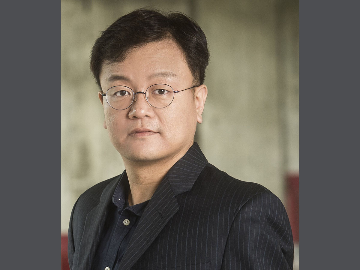 An indoor headshot of Ho-Wook Jun with a blurred background.