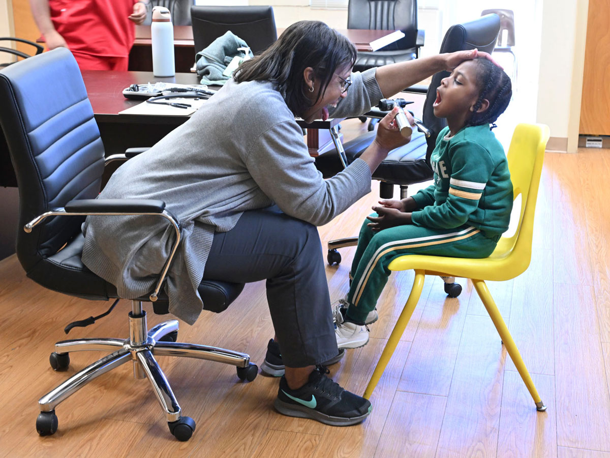 Assistant Professor and Nurse Practitioner Sherita Etheridge performs a checkup to a patient.