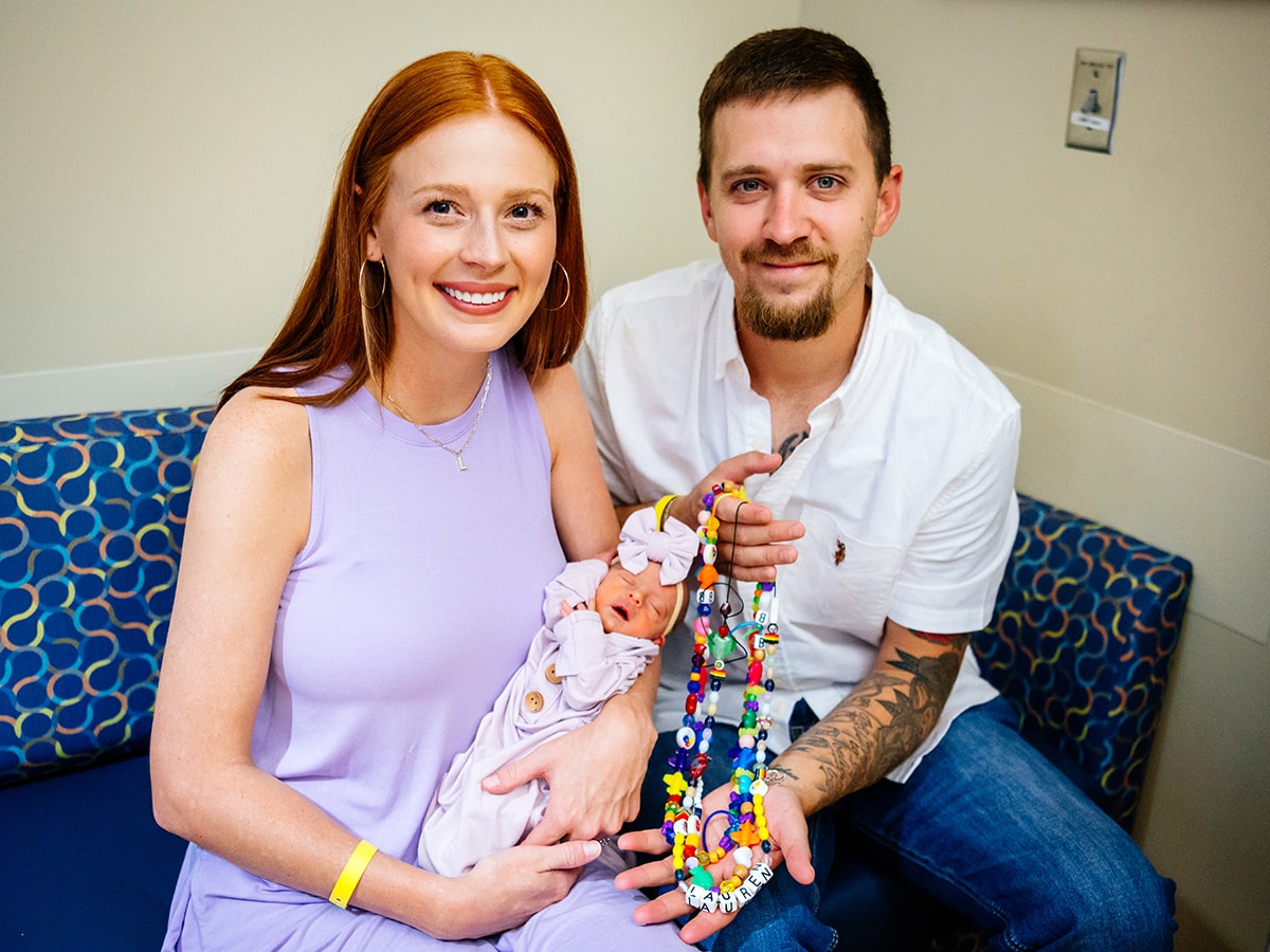 Brooke and Adam Lillie hold their daughter, Lauren, and her beads of courage, in the UAB Continuing Care Nursery