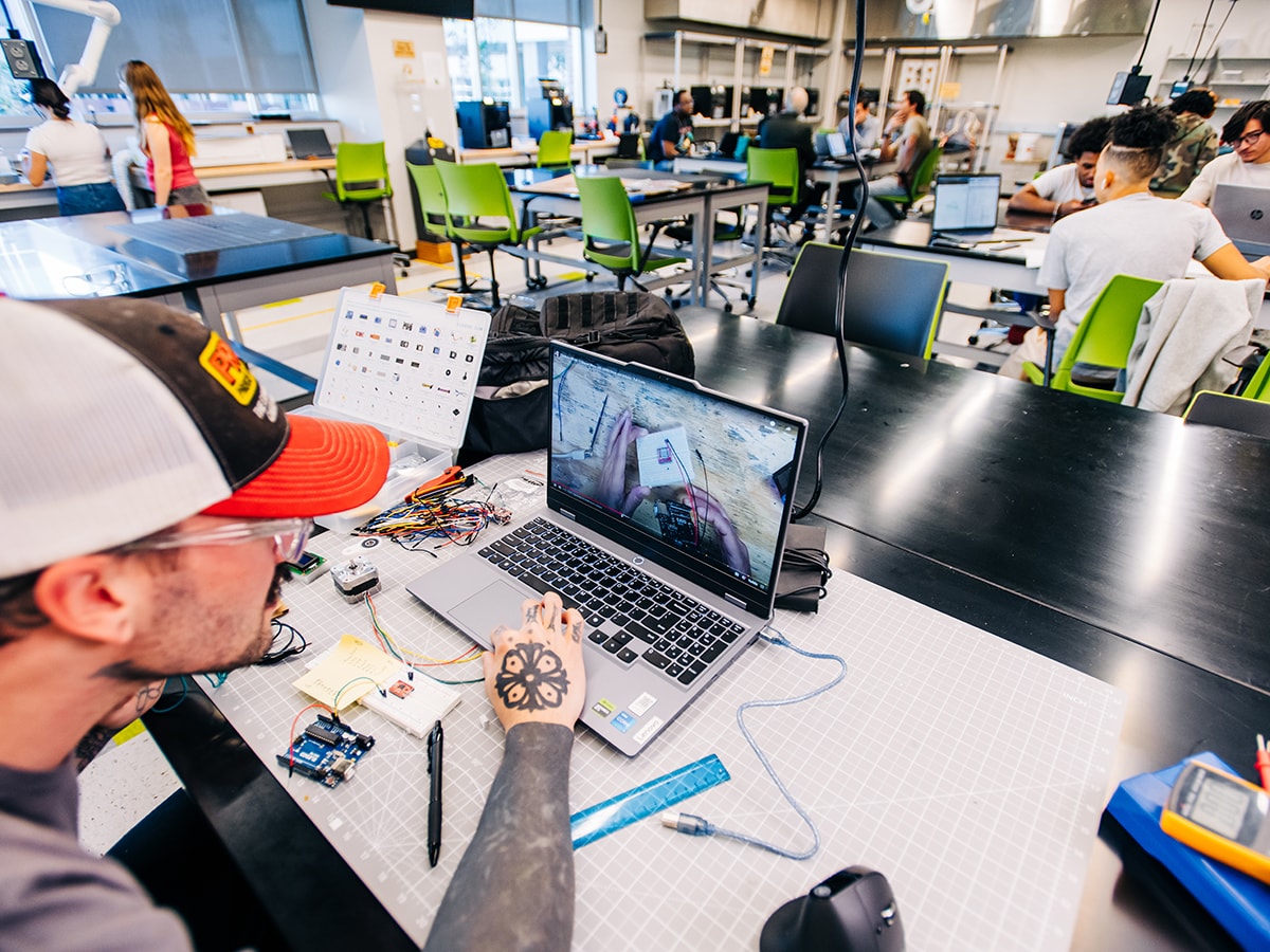 A wide-angle view of the Design x Prototyping Lab at the UAB School of Engineering with students at work.