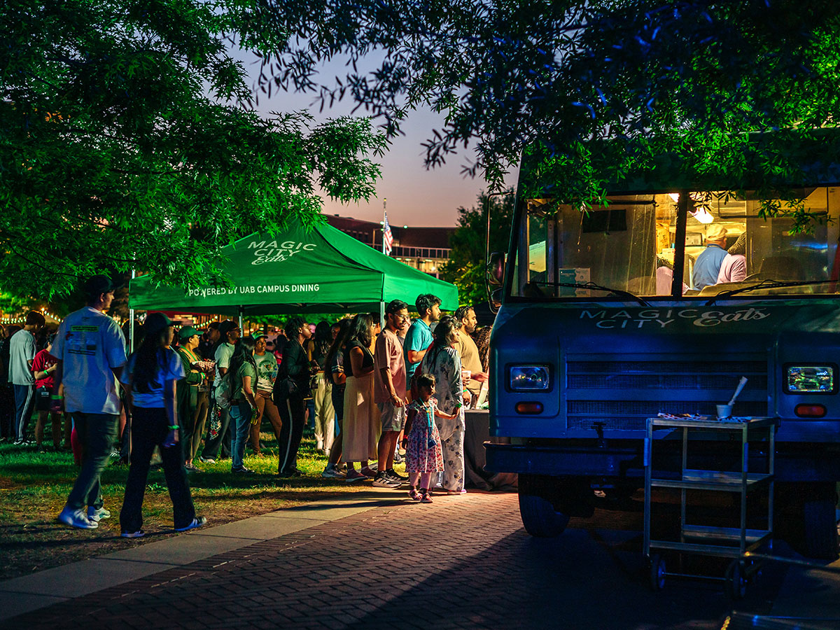 A line of students and other customers at the UAB Crawfish Boil waits to order outside a food truck in the dusk