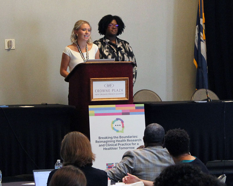 Rebecca Vales and Chloe Roth present to the conference. 